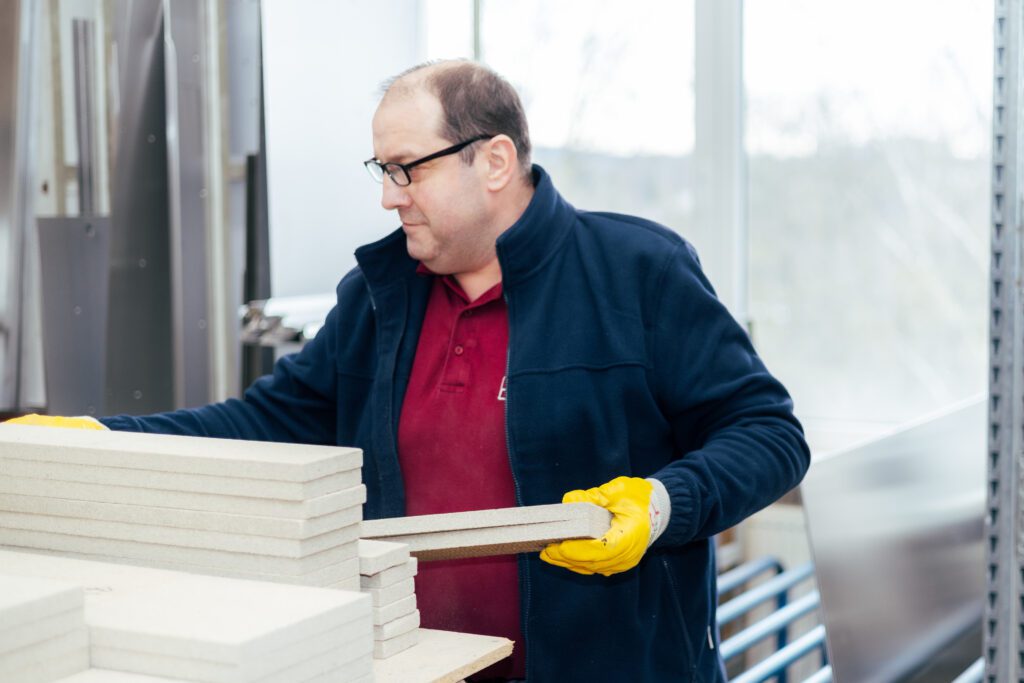Mitarbeiter hält Platten in der Hand bei Witzel Vacupress