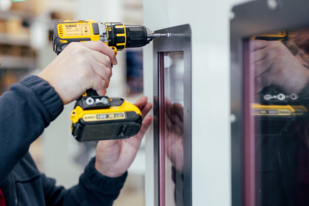 Mitarbeiter schraubt eine Schraube in einen Pre-Preg-Ofen bei Witzel Vacupress