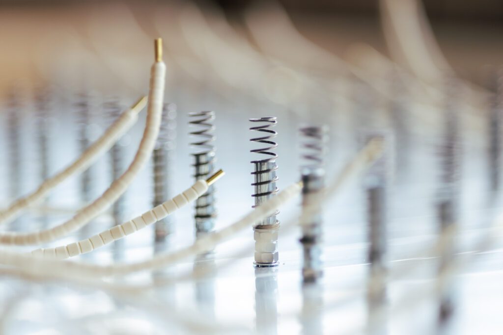 Detailaufnahme von Druckfedern mit angeschlossenen Schläuchen und Isolierungen – technische Komponenten für Vakuum- oder Laminiertechnik bei Witzel Vacupress